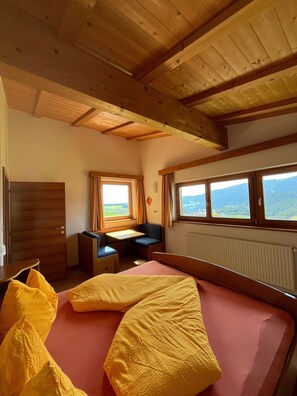 Une chambre avec un lit, un bureau et une fenêtre donnant sur un beau paysage.