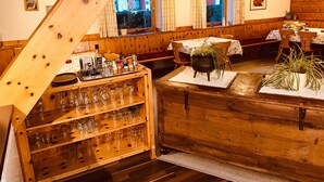 Een houten interieur met een bar, zitplaatsen en een uitzicht door een raam.