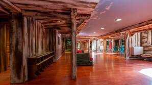 A spacious corridor with wooden beams, a bench, and a green sofa. - Apartment 'Lapon H10' with Mountain View and Balcony (Hauteluce)