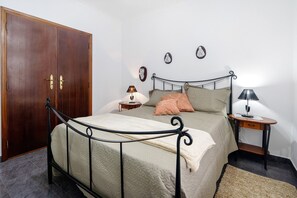 A bedroom with a bed, bedside tables, a wardrobe, and wall decorations.