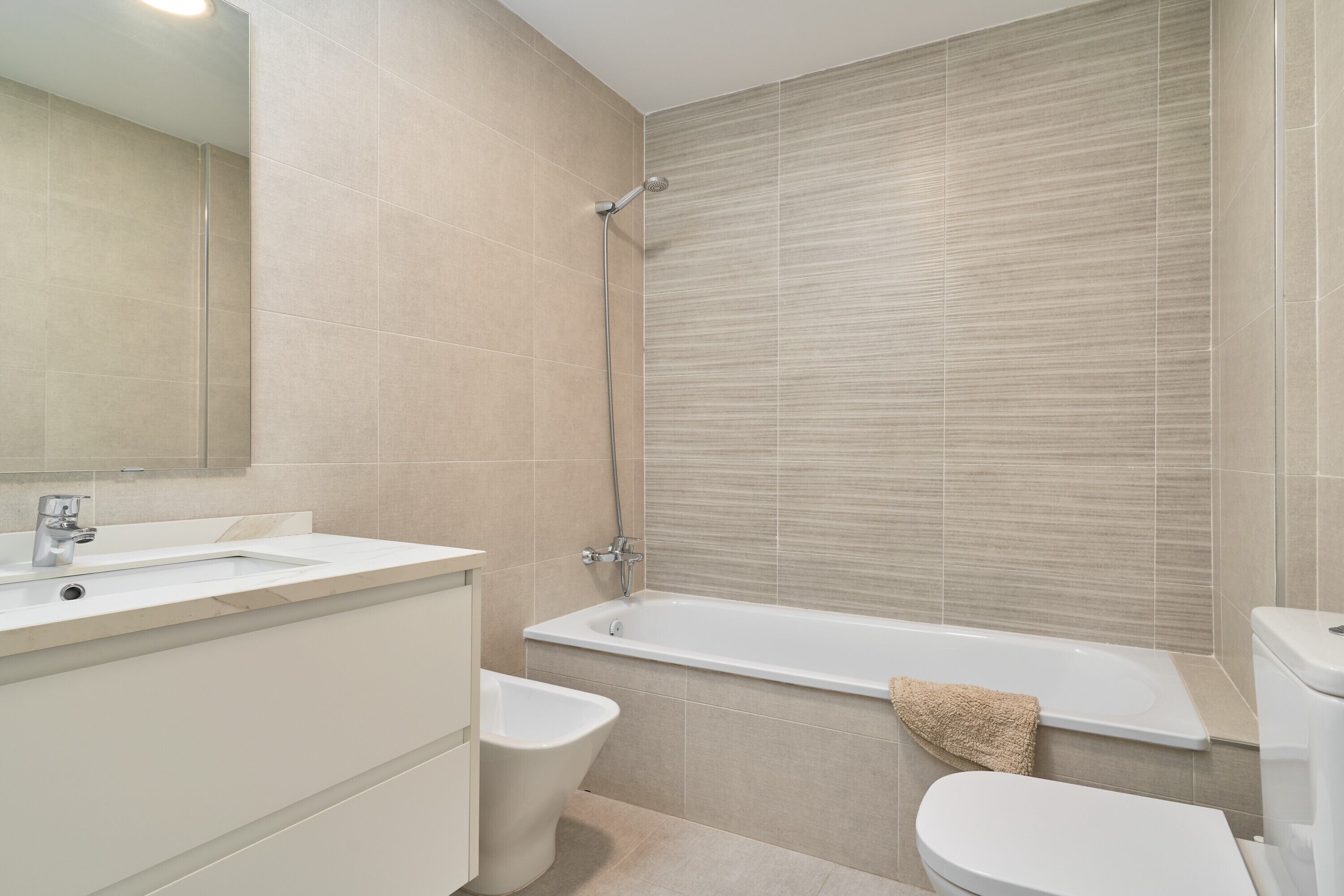 A modern bathroom with a bathtub, a bidet, and a toilet.