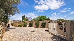 A cobblestone driveway leading to a gated entrance with a stone wall on one side and a tree on the other. - Villa 'Casa Felix' with Private Pool, Private Terrace and Wi-Fi (Loulé)