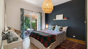 A bedroom with a bed, bedside table, lamp, and a decorative star. - Villa 'Casa Felix' with Private Pool, Private Terrace and Wi-Fi (Loulé)