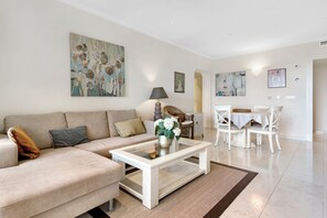 A living room with a sofa, coffee table, and dining area with chairs. - Apartment 'Gadea 11-6' with Sea View, Wi-Fi and Air Conditioning (Altea)