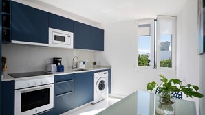 Eine moderne Küche mit Waschmaschine, Mikrowelle und Backofen.