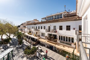 A multi-story building with balconies, outdoor seating, and a restaurant named 'Indian Restaurant.'