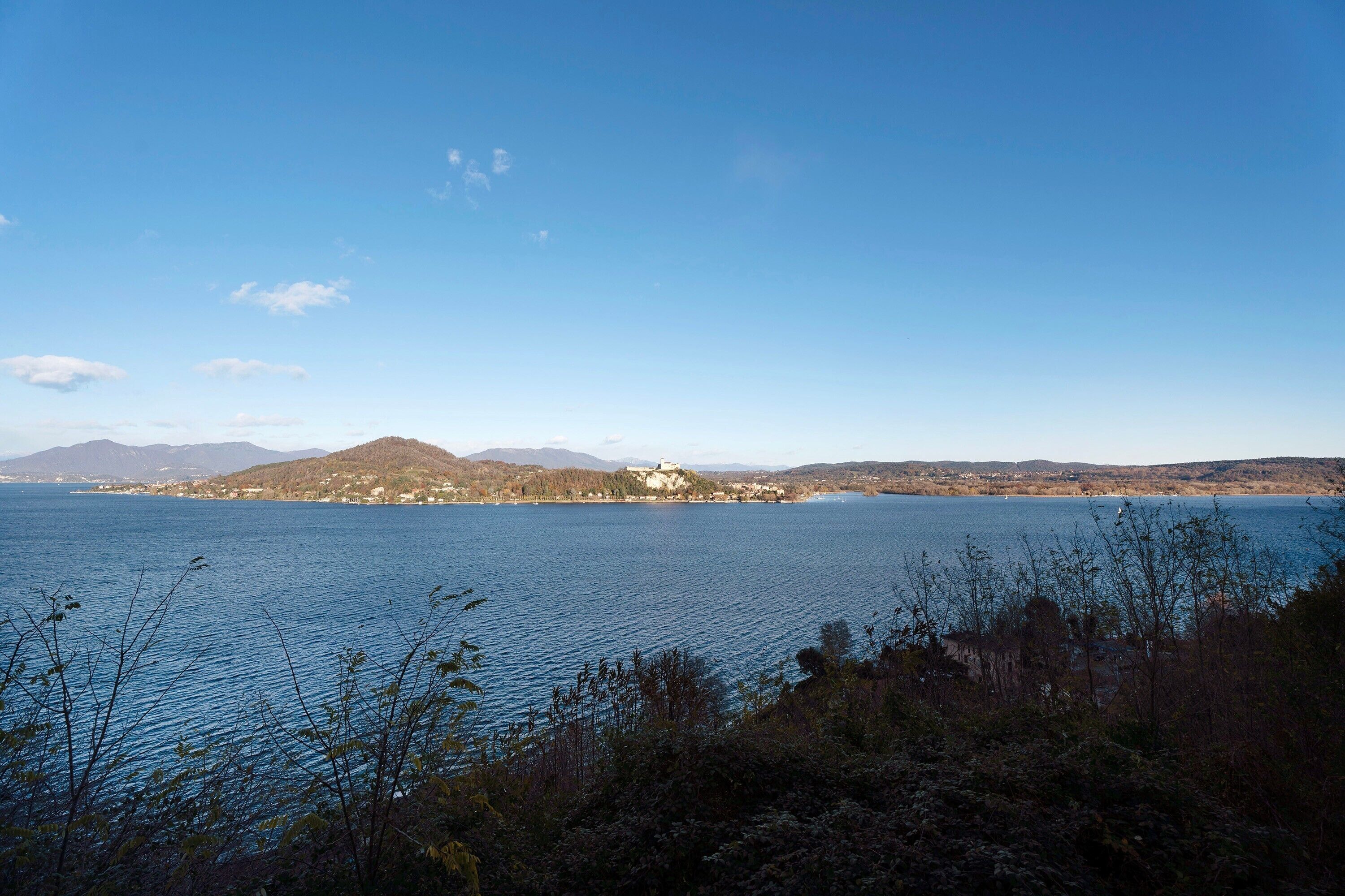 A lake with a distant mountain and a small settlement.