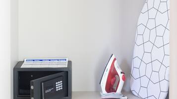 A closet with black hangers, a white ironing board, and a black iron.