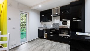 Uma cozinha moderna com armários pretos, micro-ondas e fogão a gás.