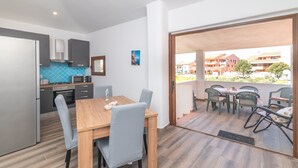 Une cuisine moderne avec un coin repas, une vue sur l’extérieur et un balcon équipé de chaises.