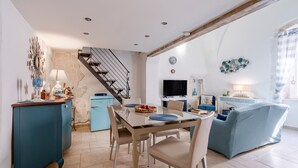 A dining area with a table, chairs, and a blue sofa.