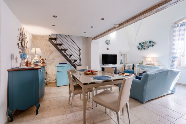 A dining area with a table, chairs, and a blue sofa.