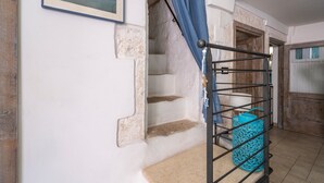 A staircase with a metal railing, a blue curtain, and a framed picture on the wall.