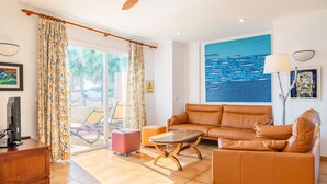 Una sala de estar con un sofá, una mesa de centro, un televisor y un cuadro.