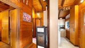 Un intérieur en bois, doté d’un système de chauffage central, de portes en bois et d’un espace cuisine.