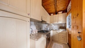 Une cuisine avec des meubles de rangement en bois, une cuisinière et un évier.