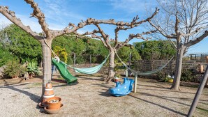 A playground with a slide, swings, and a hammock.