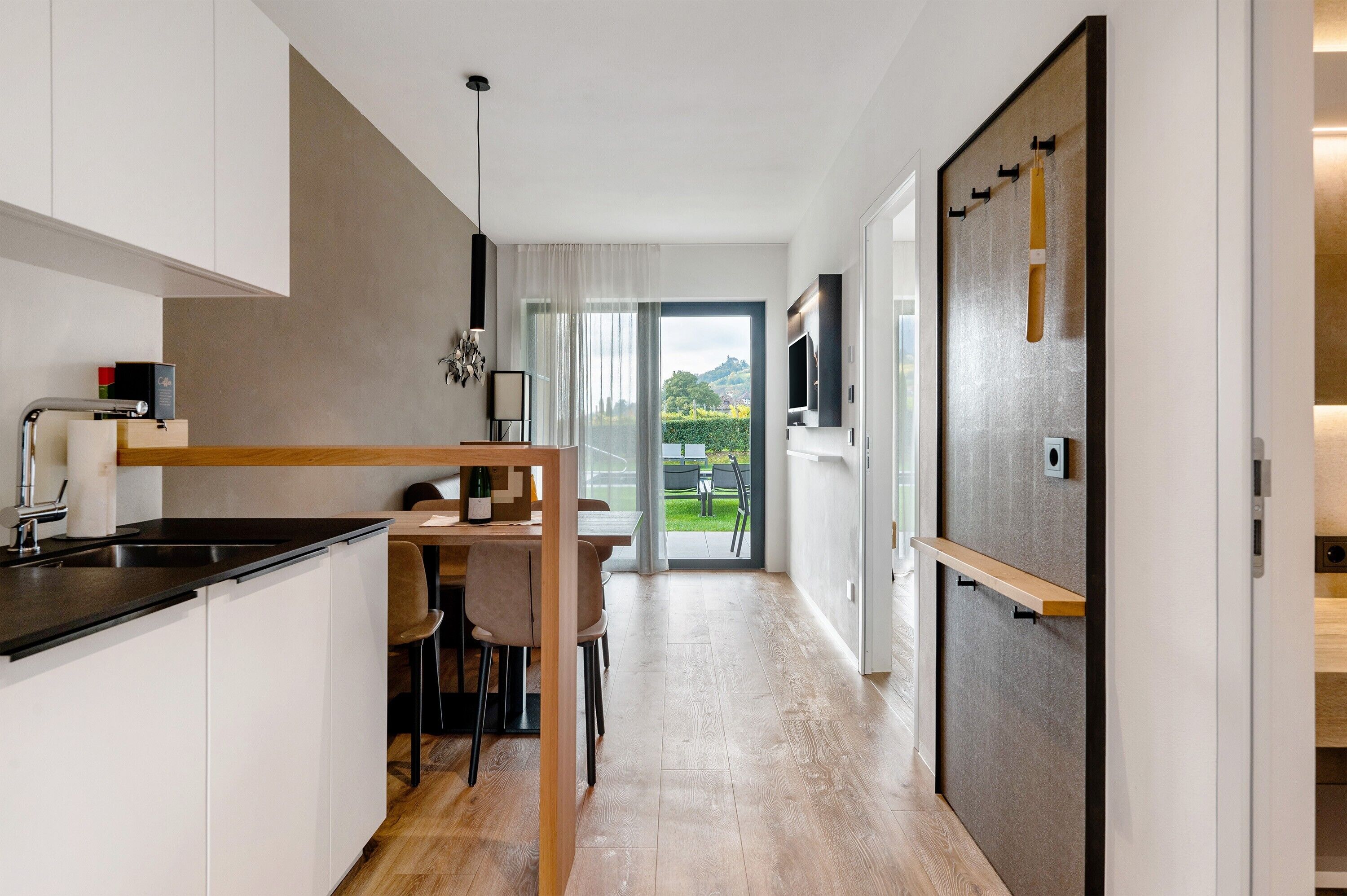 Een moderne keuken met een eethoek, uitzicht op de omgeving en een schuifdeur naar een balkon.