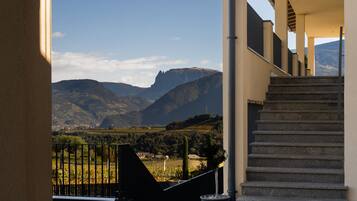 A staircase leading to a balcony overlooking a mountainous landscape with a clear sky.