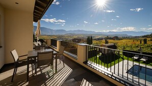 Ein Balkon mit Tisch, Stühlen, einem Grill und einem Pool.