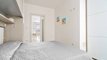 2 dormitorios, tabla de planchar con plancha, ropa de cama