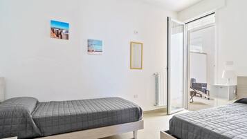 2 dormitorios, tabla de planchar con plancha, ropa de cama