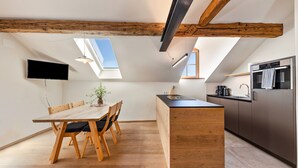 Eine moderne Küche mit einer Holztheke, eingebauten Geräten und Dachfenstern.