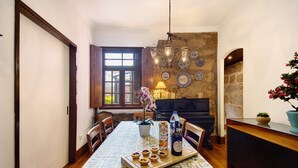 Un comedor con una mesa lista para comer, un piano y platos decorativos en la pared.