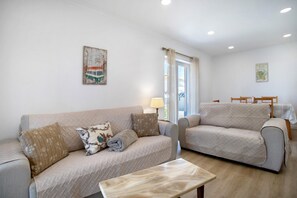 A living room with two sofas, a coffee table, and a window with curtains. - Baleal Atlantic Villa (Ferrel)