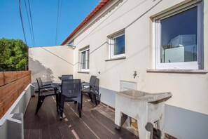 A patio with a table and chairs, a concrete planter, and a window with a white frame. - Lovely vacation home Baleal atlantic 6 (Ferrel)