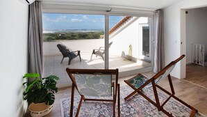 Ein Balkon mit Blick, ein Blumentopf und zwei Stühle.