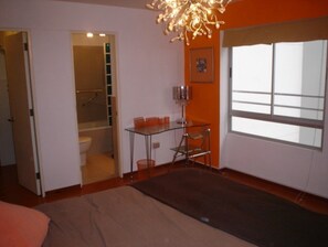 Relax in a cozy space with a glass table, comfortable seating area, and large window.