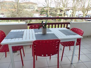 Enjoy a meal or a moment of peace on this outdoor space with a table, chairs, and a potted plant.