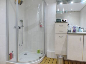 Enjoy a refreshing shower in this bathroom with a glass-enclosed shower area, handheld showerhead, and wall-mounted faucet.
