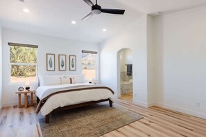 A bedroom with a bed, a ceiling fan, and a window. - Two Junipers | Escape to Southern Utah (Hurricane)