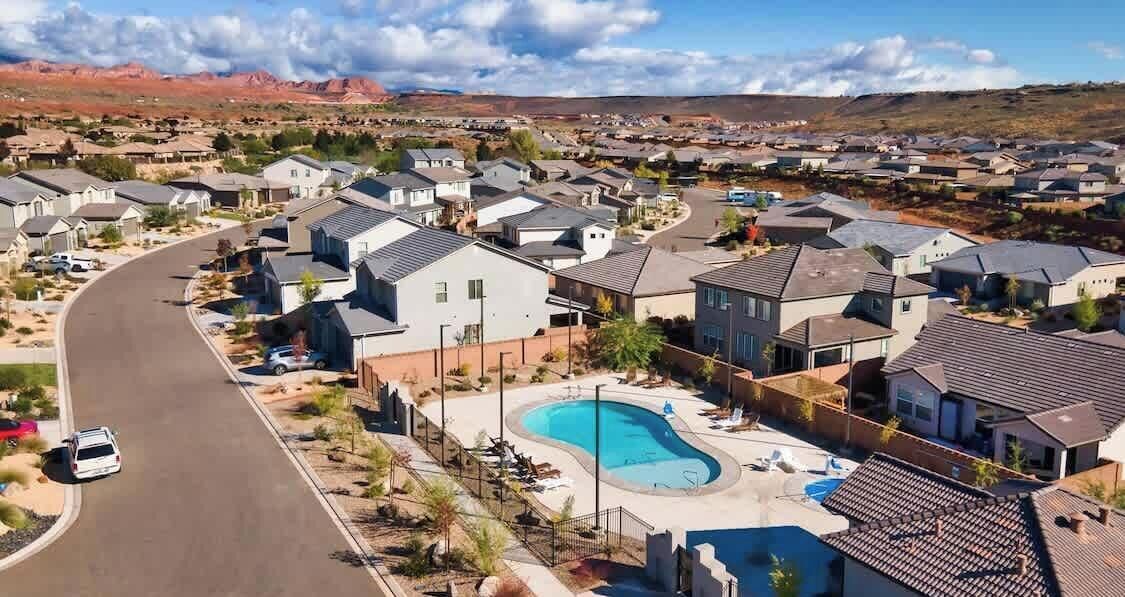 A residential area with houses, a curved road, and a swimming pool.
