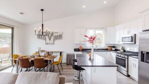 A modern kitchen with white cabinetry, stainless steel appliances, and a central island.