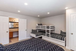 A bedroom with bunk beds, a bathroom with a mirror, and a kitchenette. - The MVP at Sports Village | Pet Friendly Retreat (Saint George)
