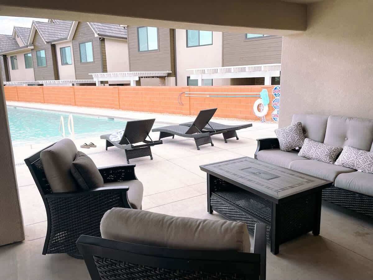 Un espace aménagé au bord de la piscine, avec des chaises longues, un canapé et une table basse.