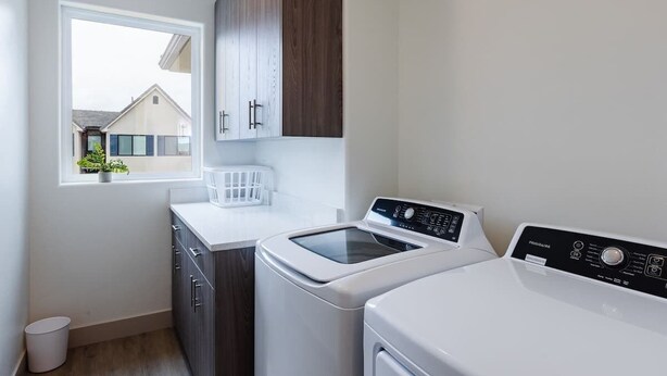 A laundry room with a washing machine, dryer, and a window with a view of a house. - Lava Flow @ Heritage Point - Santa Clara (Santa Clara)