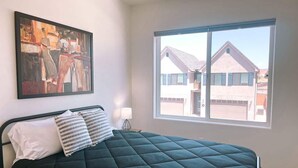 A bedroom with a bed, a window, and a painting on the wall. - Lava Flow @ Heritage Point - Santa Clara (Santa Clara)
