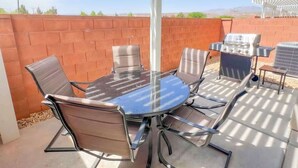 A patio with a round glass table and metal chairs, a barbecue grill, and a pergola structure. - Lava Flow @ Heritage Point - Santa Clara (Santa Clara)