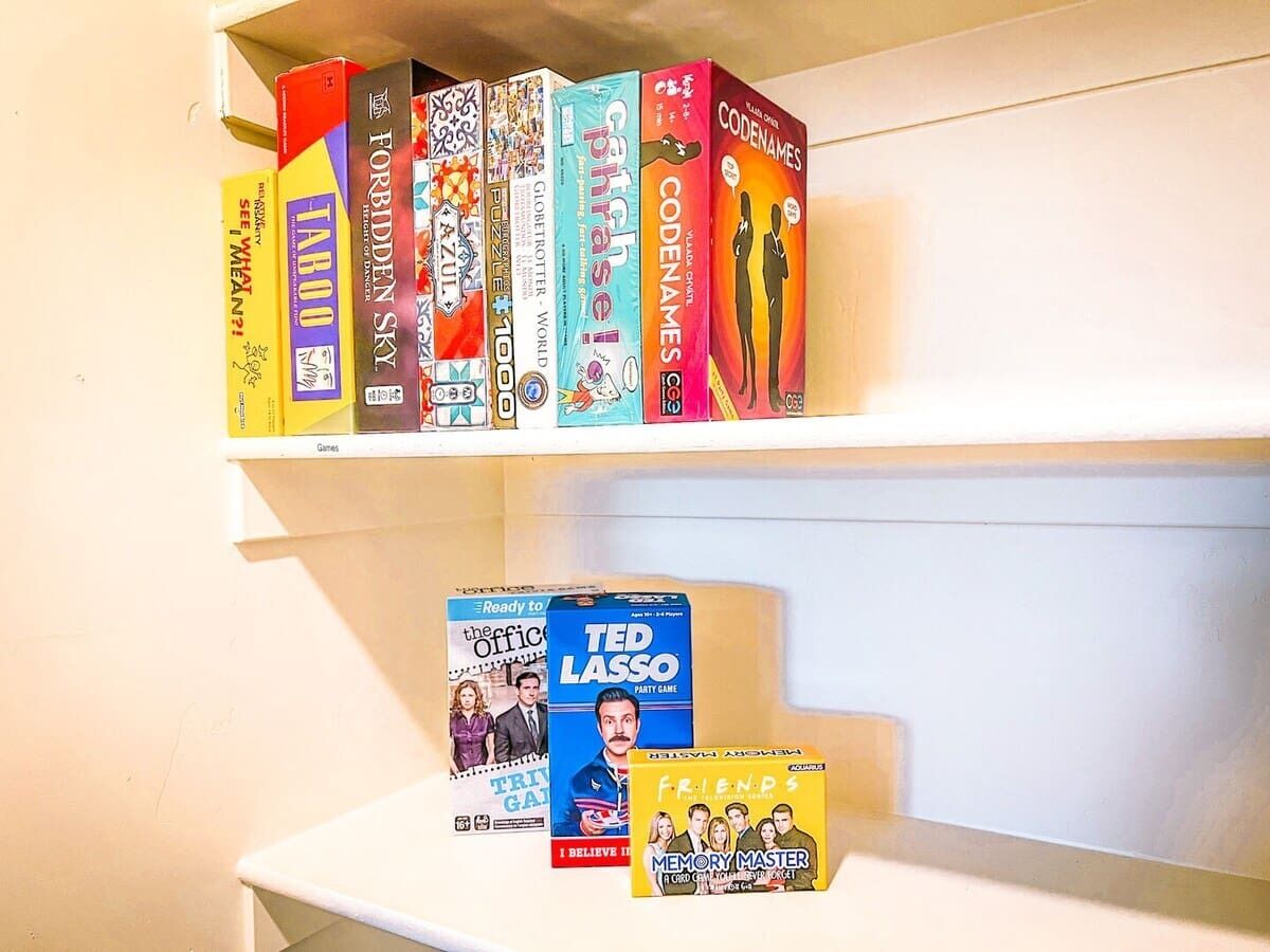Ein Bücherregal mit verschiedenen Gesellschaftsspielen und einigen Büchern.