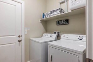 A laundry room with two white washers and dryers, a shelf with folded towels, and a motivational sign. - 3 Bed/3.5 Bath | The Casitas | Close to Adventure (Washington)