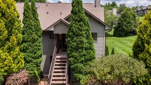 A two-story house with a front porch and a staircase leading to the entrance. - Chetola Chestnut 8 - close to downtown Blowing Rock! (Blowing Rock)