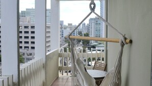 A hammock on a balcony with a city view. - Condado Oasis on Ashford Ave: Oceanview and Pool (San Juan)