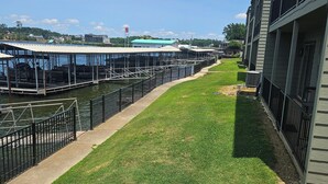 A waterfront property with a grassy area, a dock, and a building with balconies. -  Perfectly located Lake Hamilton lake front condo. 5 miles to Oaklawn Race Track (Lake Hamilton)