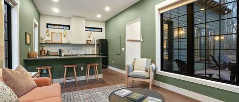 A modern living room with a sofa, a coffee table, and a large window.