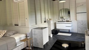 Un bagno moderno con una vasca freestanding, un lavabo con specchio e un water.