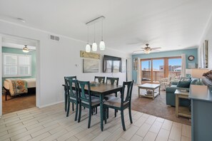 Un vaste espace de vie comprenant une table à manger, des chaises, un canapé et un balcon avec vue.